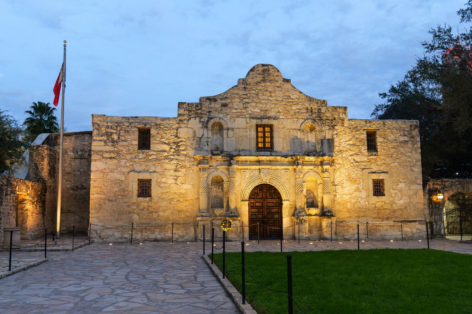 The Alamo floodlit under an evening sky