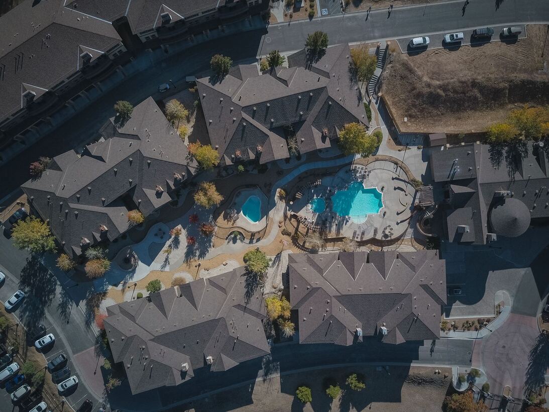 Aerial view of an apartment community courtyard with two pools