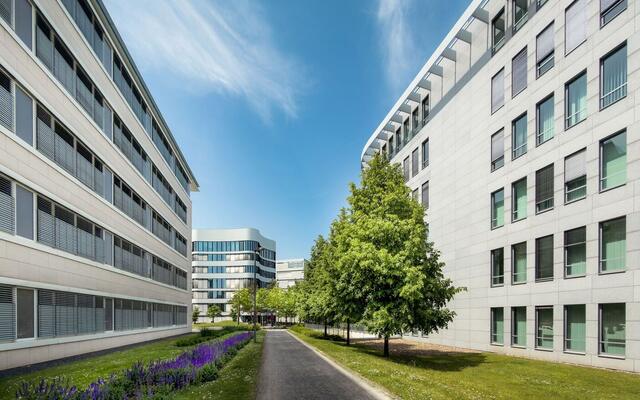 Modern office buildings along a landscaped walkway