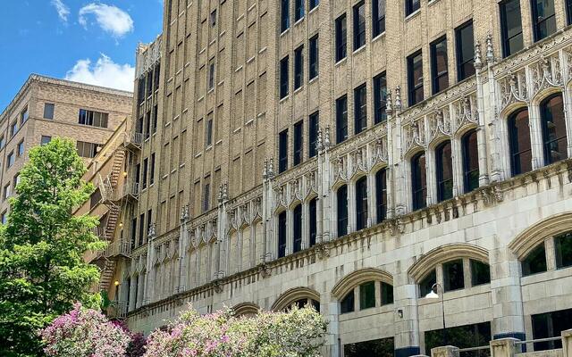 Art Deco building and blooming crepe myrtles above the San Antonio River