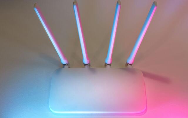 Wireless router with four raised antennas lit in soft colour