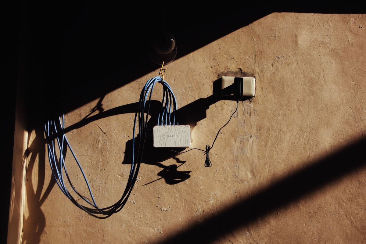 Coiled network cable and a wall outlet in raking sunlight