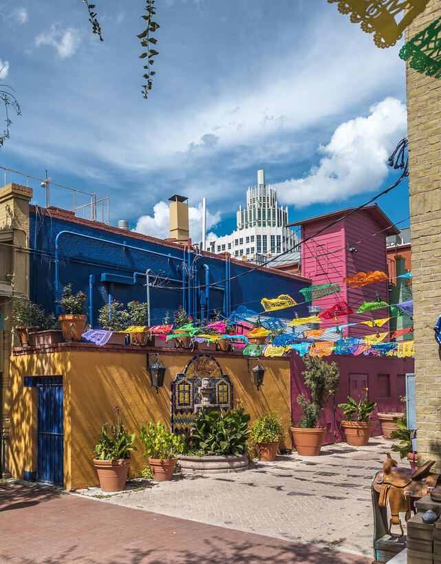 Papel picado banners over a painted courtyard in the San Antonio market district