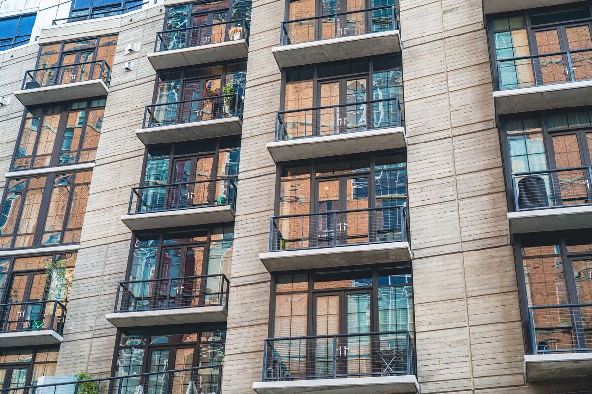 Mid-rise apartment facade with recessed balconies and tall windows