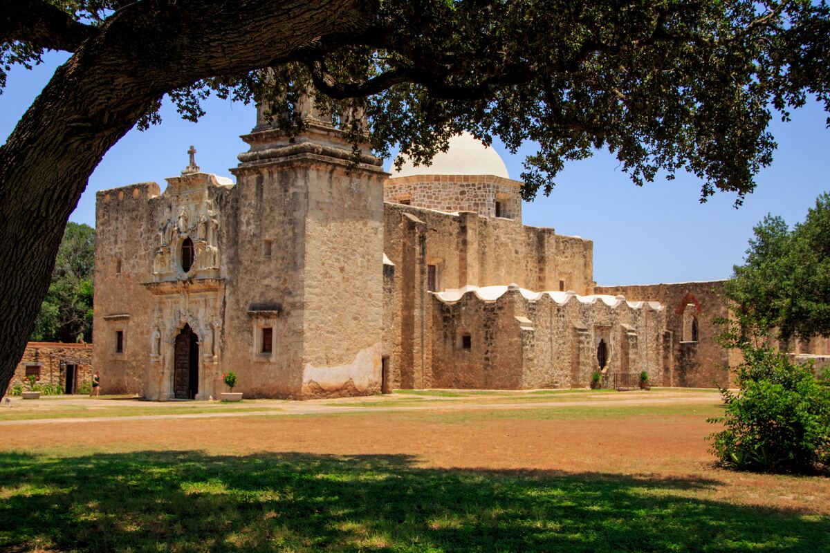 Mission San Jose framed by a live oak branch in San Antonio