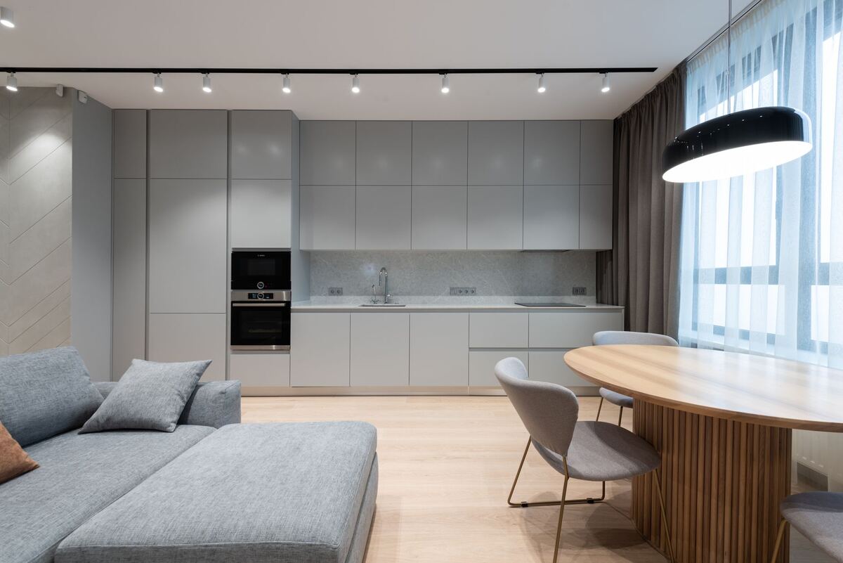 Open-plan apartment kitchen and living area with a dining table