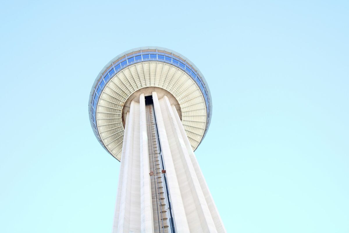 Tower of the Americas seen from directly below against a pale sky