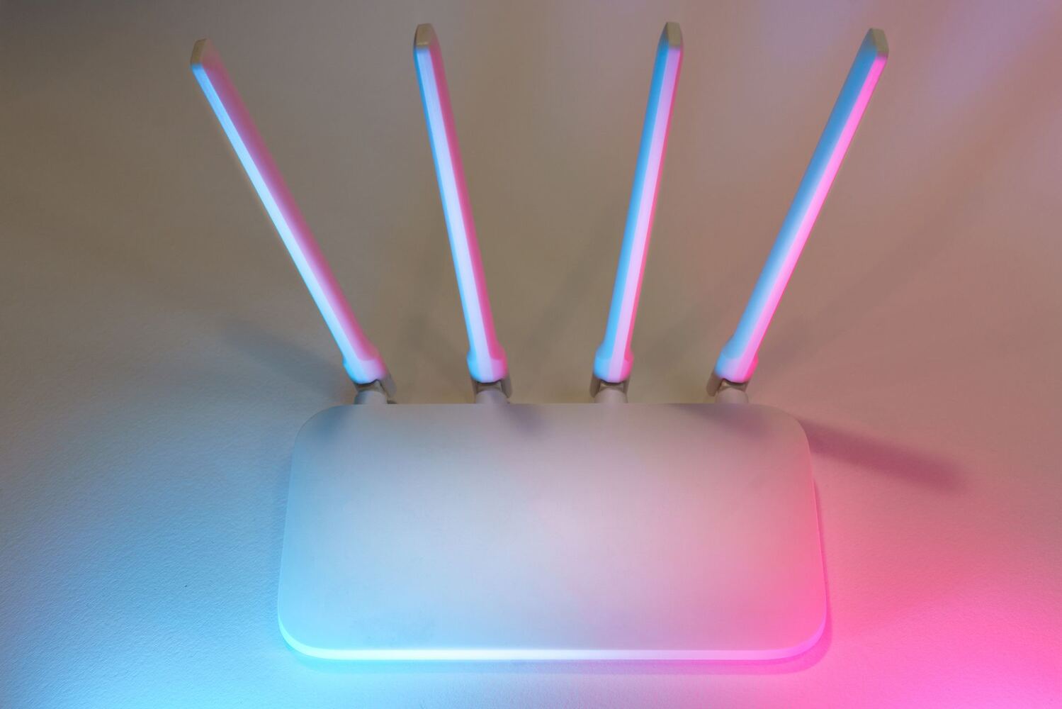 Wireless router with four raised antennas lit in soft colour